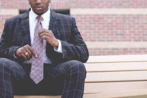 Lawyer wearing a purple tie and sitting on a bench.