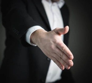 A lawyer offering to shake a client's hand.